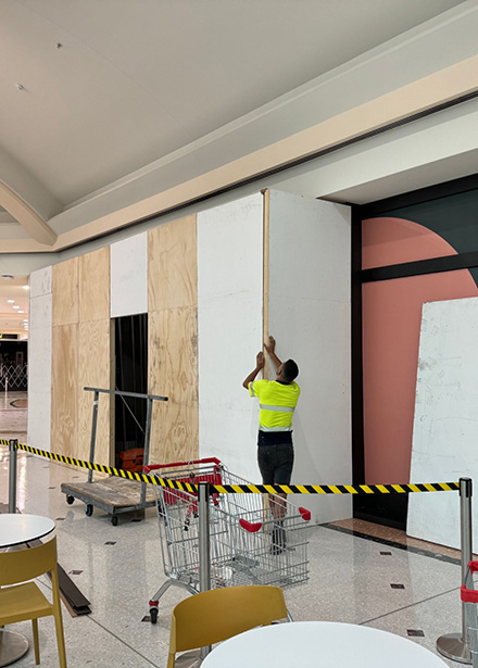 West Maintain worker installs hoarding at a vicinity shopping centre